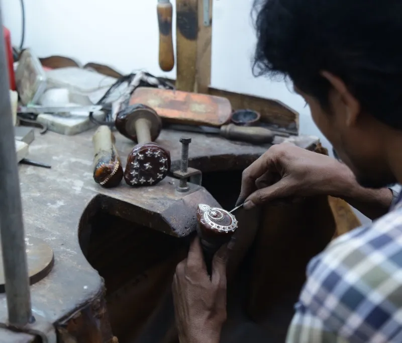 Artisan working on jewelry repair at the bench